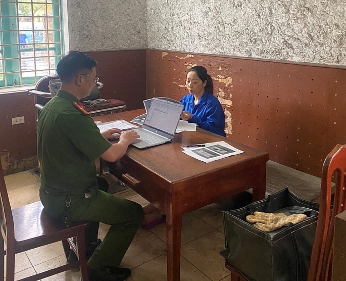 Điều tra viên lấy lời khai Phạm Thị Thanh Huệ. Ảnh: CQCA